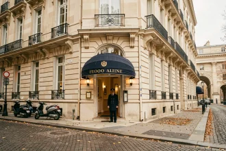 Façade élégante du Paris Orsay Hôtel face au musée d'Orsay avec portier en uniforme sur un boulevard parisien en automne